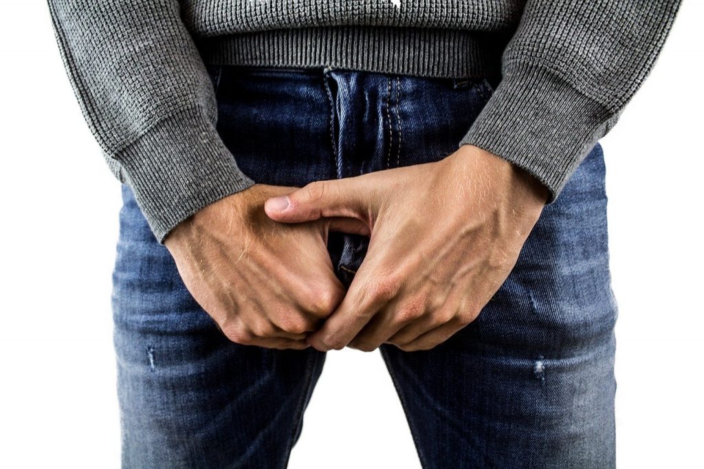 man wearing jeans with hands in front of groin area