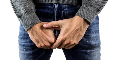 man wearing jeans with hands in front of groin area