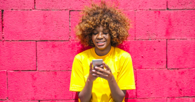Young woman using phone, smiling