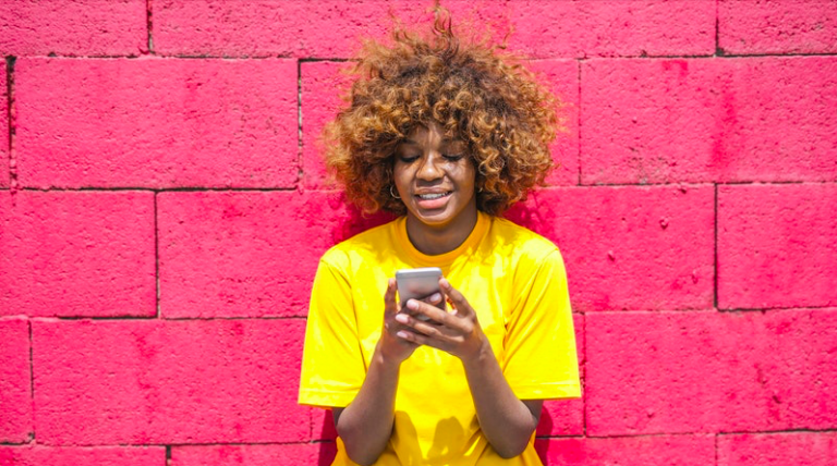 Young woman using phone, smiling