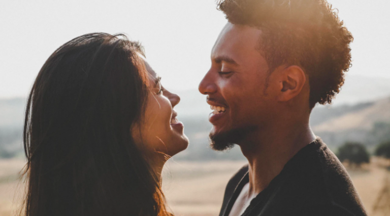 Smiling couple with sea behind