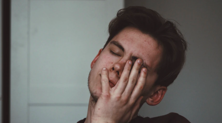 young man holding face looking unhappy